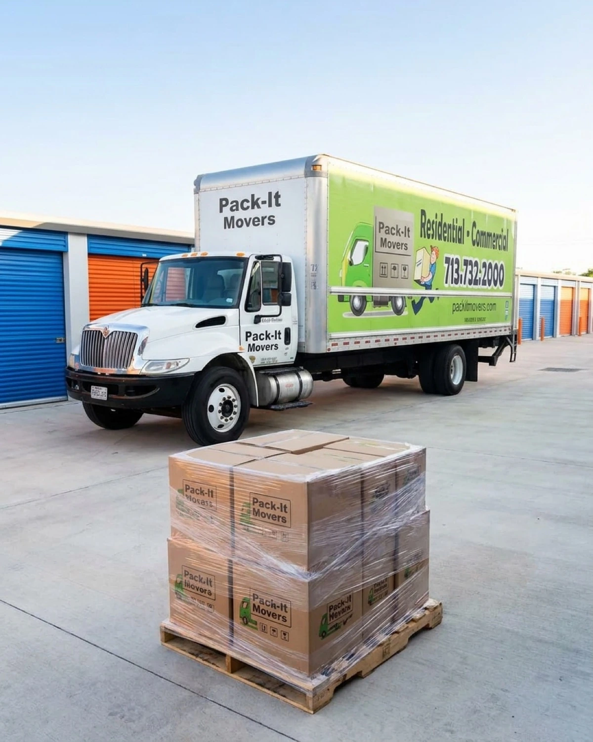 Pack-It Movers branded truck at a Houston self-storage facility with palletized boxes